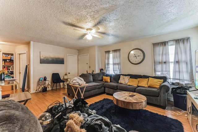 living room featuring plenty of natural light, ceiling fan, a textured ceiling, and light hardwood / wood-style flooring