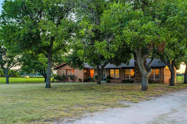 view of front of home with fence, a front lawn, and brick siding