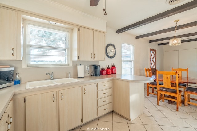 kitchen featuring kitchen peninsula, ceiling fan, beamed ceiling, decorative light fixtures, and sink