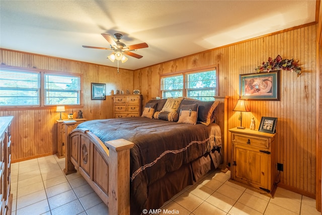 tiled bedroom with ceiling fan, multiple windows, and wooden walls