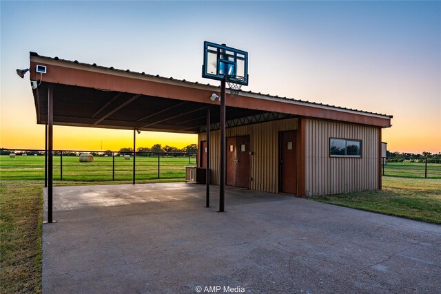 parking at dusk with a carport and a lawn