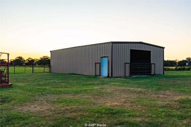 outdoor structure at dusk featuring a yard