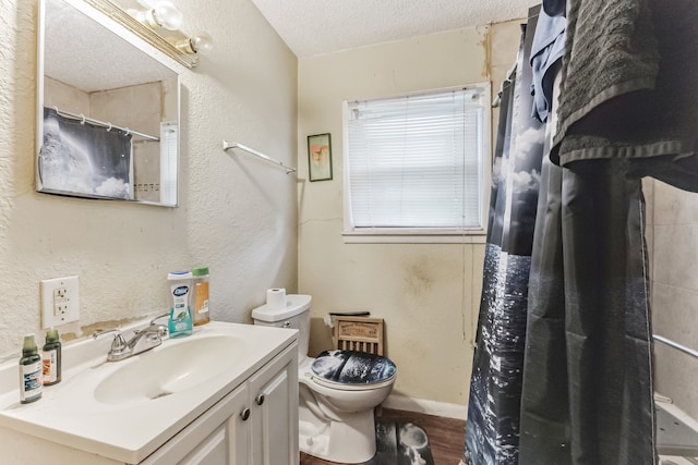 bathroom with hardwood / wood-style floors, toilet, vanity, and a textured ceiling