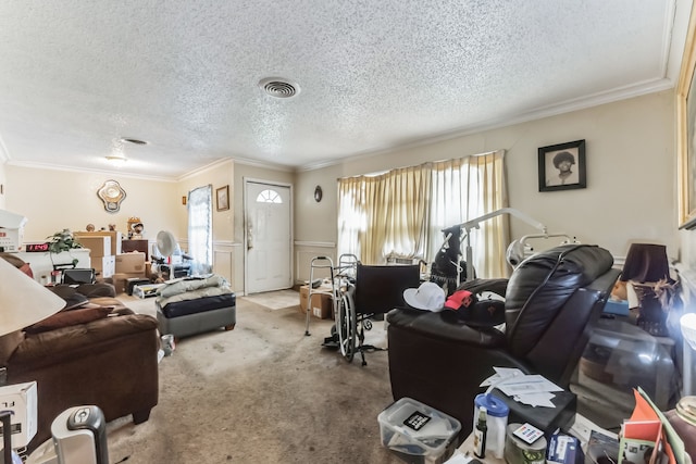 living room featuring a healthy amount of sunlight, ornamental molding, carpet floors, and a textured ceiling