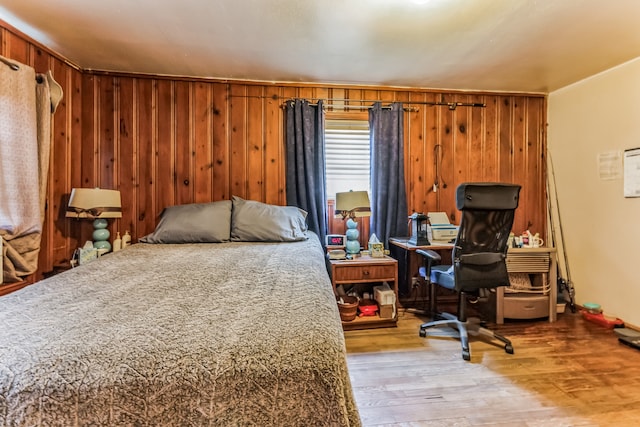 bedroom featuring light hardwood / wood-style floors and wood walls