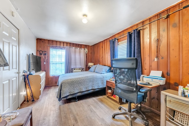 bedroom featuring wood walls and light hardwood / wood-style floors