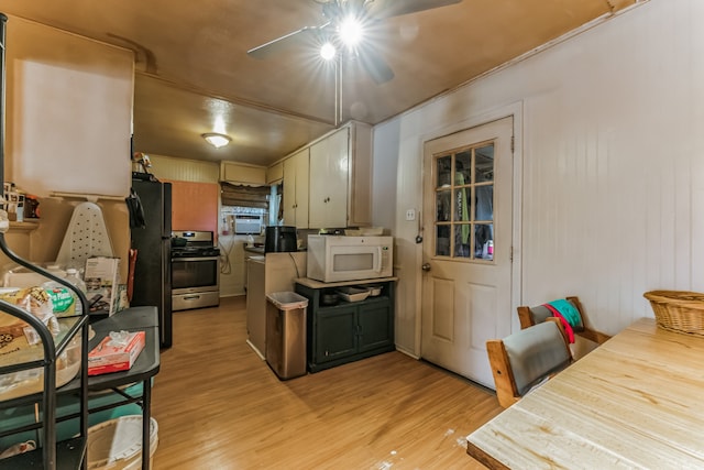 kitchen featuring light wood-type flooring, stainless steel stove, and black refrigerator