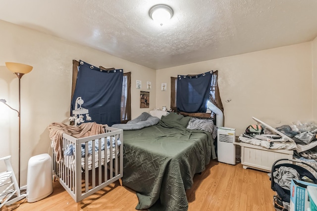 bedroom featuring hardwood / wood-style flooring and a textured ceiling