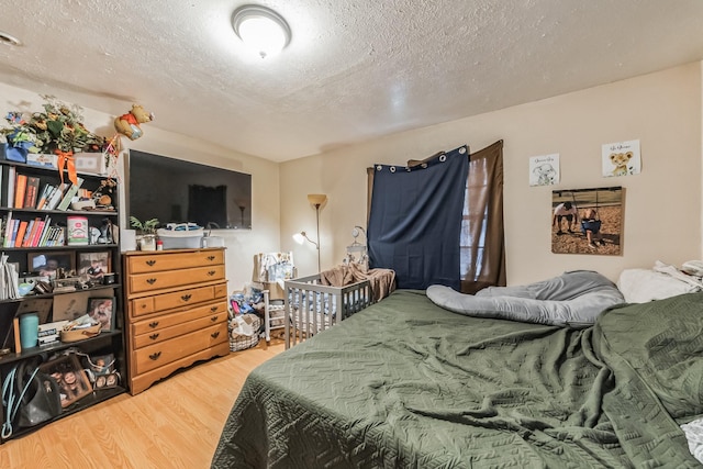 bedroom featuring hardwood / wood-style floors and a textured ceiling