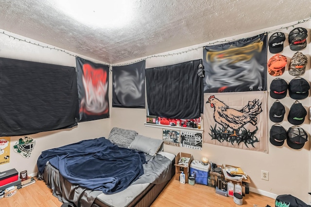 bedroom featuring wood-type flooring and a textured ceiling