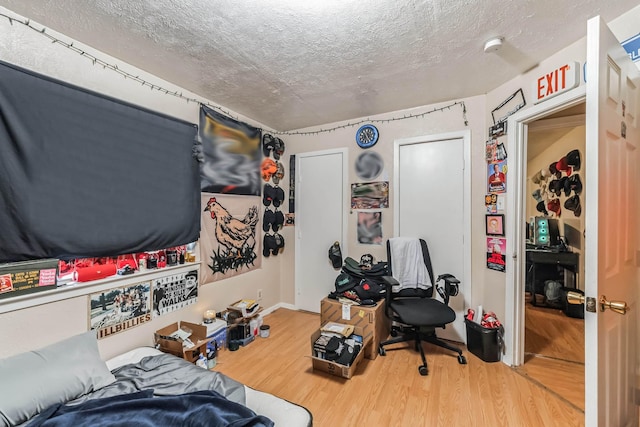 bedroom featuring hardwood / wood-style floors and a textured ceiling