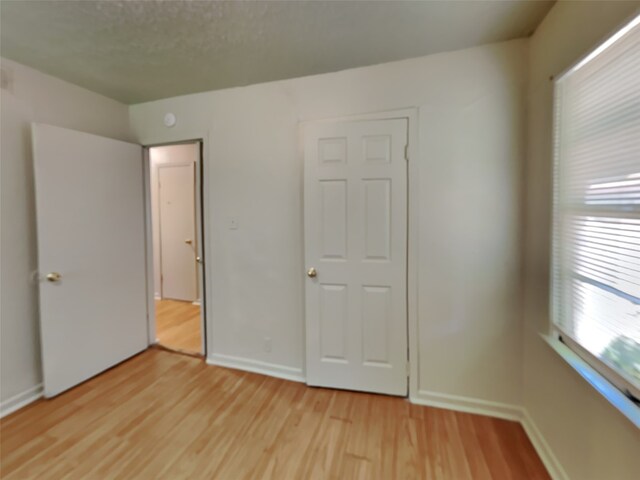 unfurnished bedroom featuring light hardwood / wood-style flooring and a closet