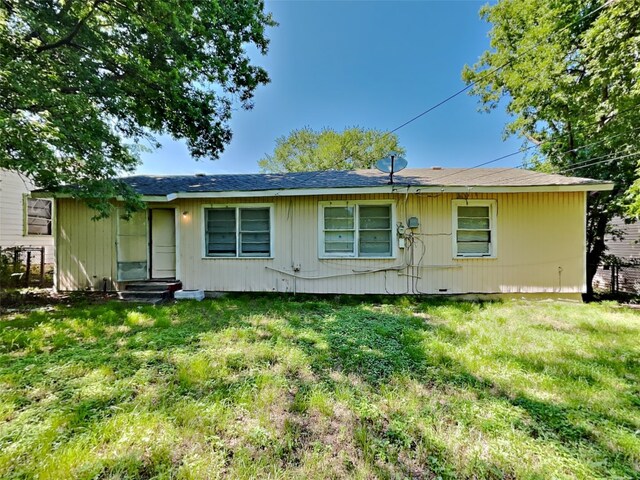 back of property with a lawn