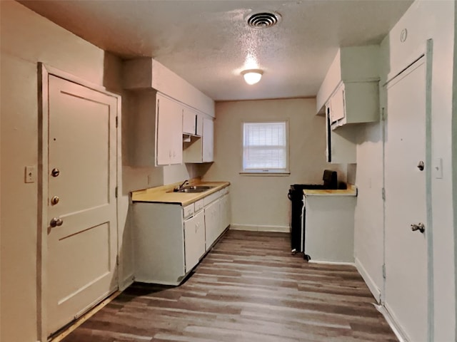 kitchen with white cabinetry, range, sink, light hardwood / wood-style floors, and a textured ceiling