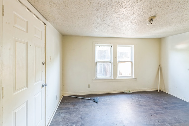 unfurnished room with a textured ceiling