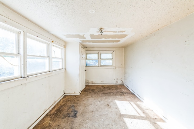 unfurnished room with a textured ceiling