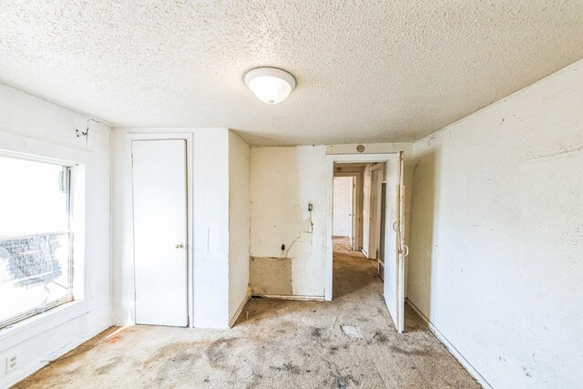 unfurnished bedroom with carpet flooring and a textured ceiling