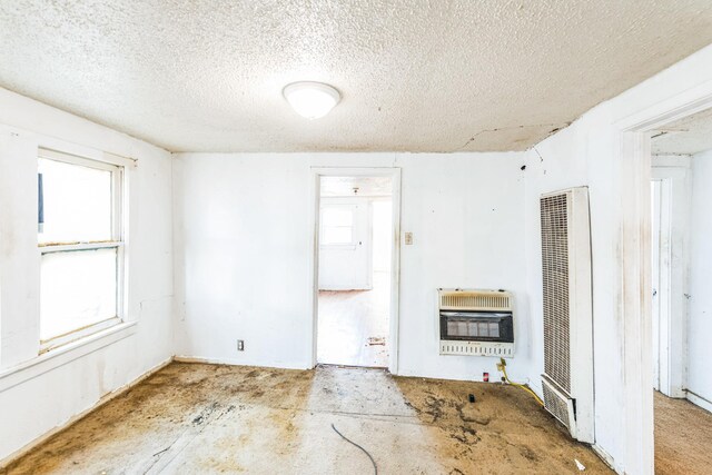 unfurnished living room featuring a textured ceiling and heating unit