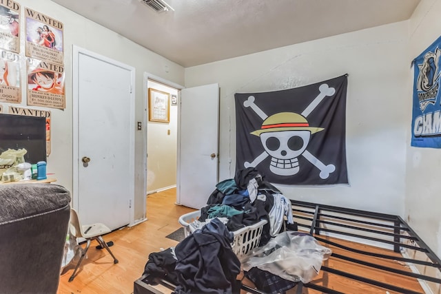 bedroom featuring visible vents and wood finished floors