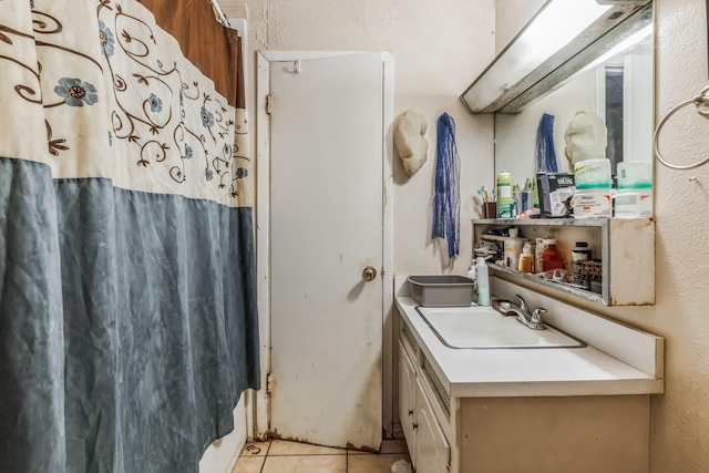 bathroom with tile patterned flooring, a textured wall, vanity, and a shower with shower curtain