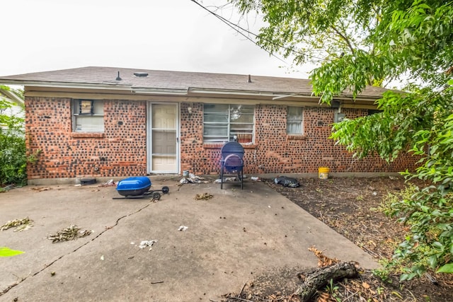 rear view of house with brick siding and a patio area