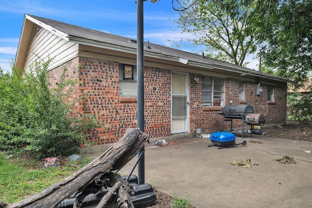 rear view of house featuring a patio area and brick siding