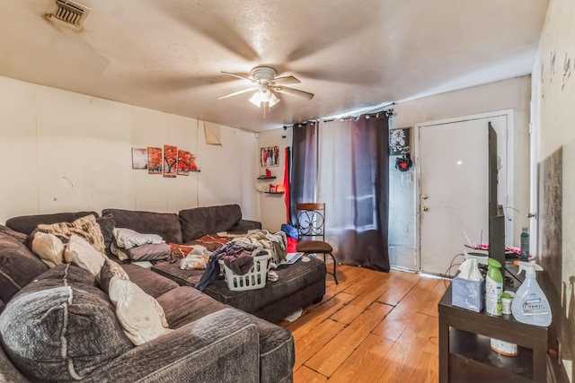 living room with visible vents, ceiling fan, and hardwood / wood-style floors