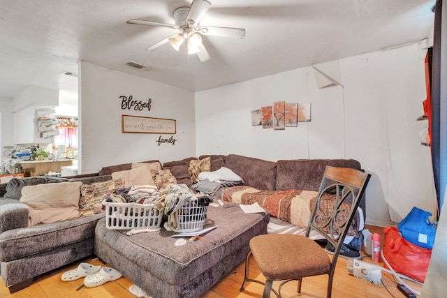 living area featuring ceiling fan, wood finished floors, and visible vents