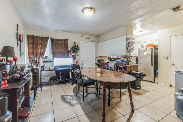 dining space featuring a textured ceiling, light tile patterned flooring, and visible vents