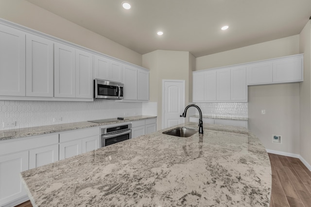 kitchen featuring stainless steel appliances, white cabinets, light hardwood / wood-style floors, and sink