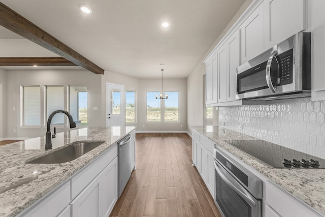 kitchen featuring hanging light fixtures, white cabinets, dark hardwood / wood-style flooring, stainless steel appliances, and sink