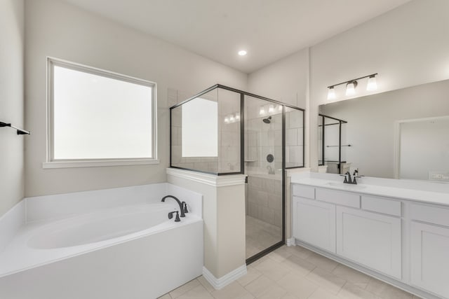 bathroom with tile patterned flooring, independent shower and bath, and vanity