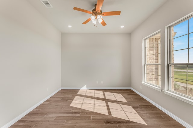 unfurnished room featuring ceiling fan, wood-type flooring, and a healthy amount of sunlight