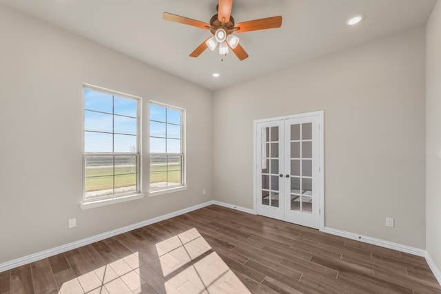 spare room featuring dark wood-type flooring, ceiling fan, and french doors