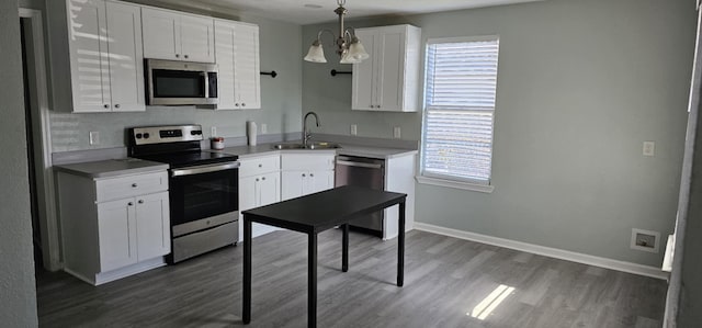 kitchen featuring sink, dark hardwood / wood-style flooring, decorative light fixtures, white cabinets, and appliances with stainless steel finishes