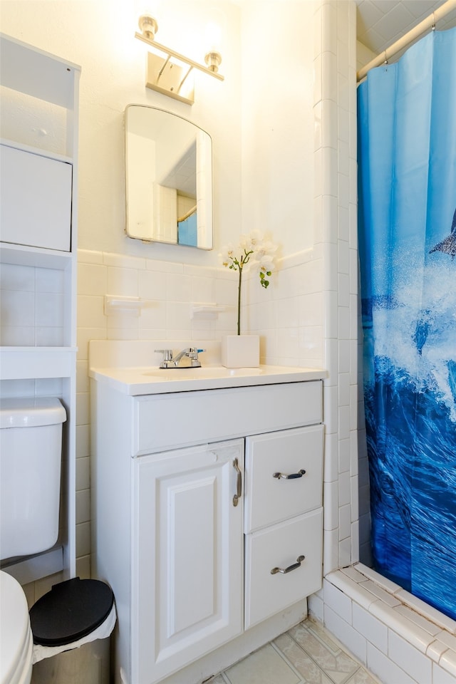 bathroom featuring tasteful backsplash, tile walls, tile patterned floors, toilet, and vanity