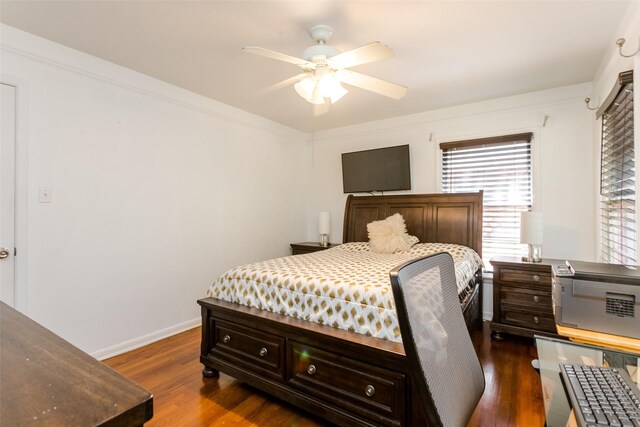 bedroom with ceiling fan, multiple windows, and dark hardwood / wood-style flooring