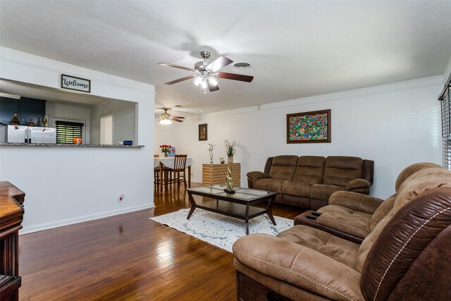 living room featuring crown molding, dark hardwood / wood-style floors, and ceiling fan