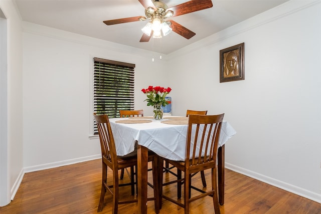 dining space with ceiling fan, wood-type flooring, and ornamental molding