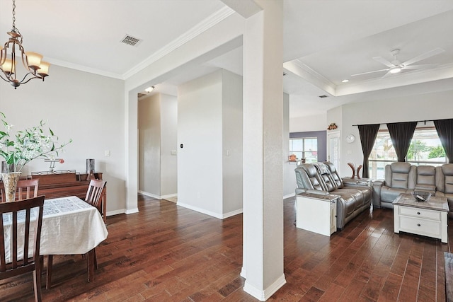 dining area with dark wood-type flooring, crown molding, and a wealth of natural light