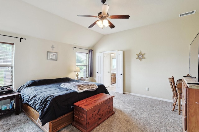 bedroom featuring vaulted ceiling, light carpet, ensuite bathroom, and ceiling fan