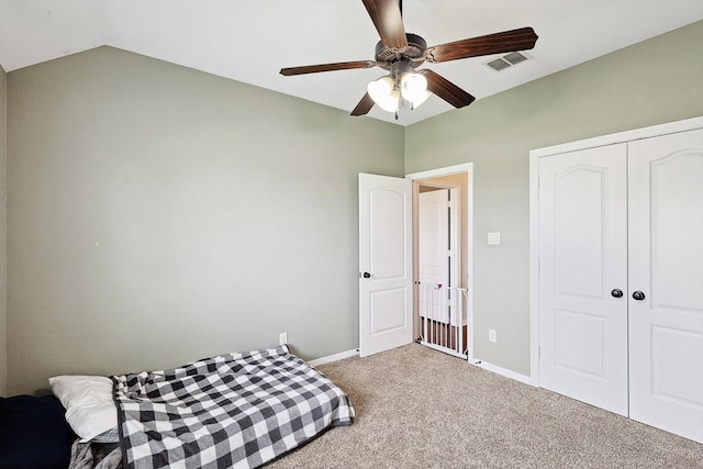 bedroom featuring ceiling fan, lofted ceiling, carpet floors, and a closet