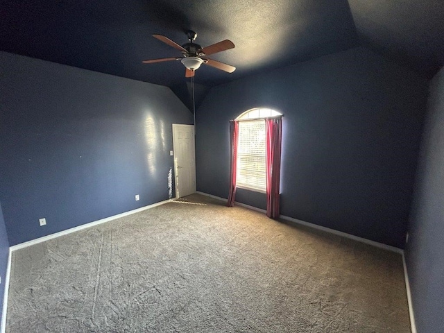 carpeted empty room featuring vaulted ceiling and ceiling fan