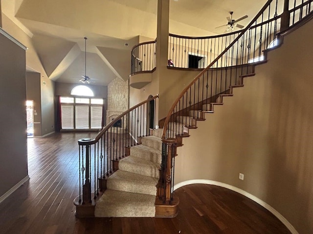 stairway with hardwood / wood-style floors, high vaulted ceiling, and ceiling fan