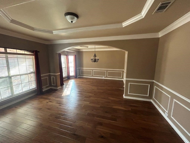 spare room with a raised ceiling, crown molding, and dark hardwood / wood-style flooring