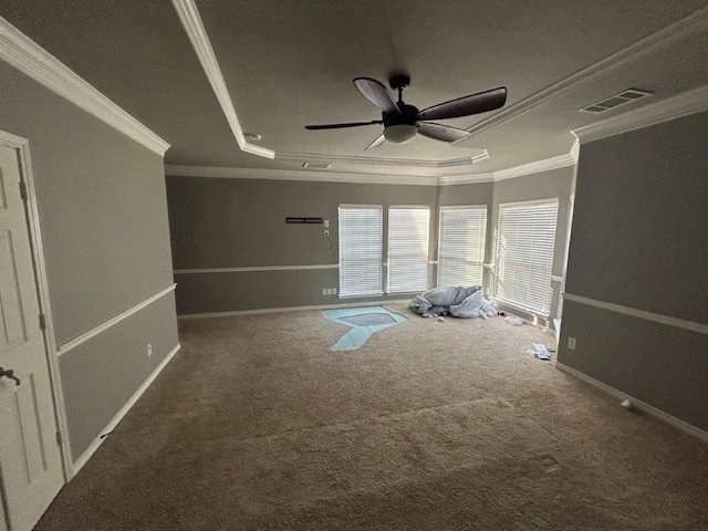 carpeted spare room with crown molding, ceiling fan, and a tray ceiling