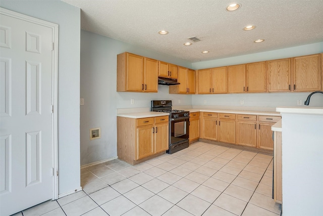 kitchen featuring a textured ceiling, light tile patterned floors, sink, and black gas range oven