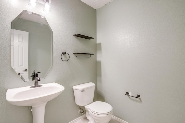 bathroom featuring a textured ceiling and toilet