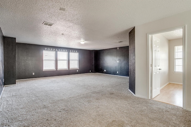 carpeted empty room featuring a textured ceiling