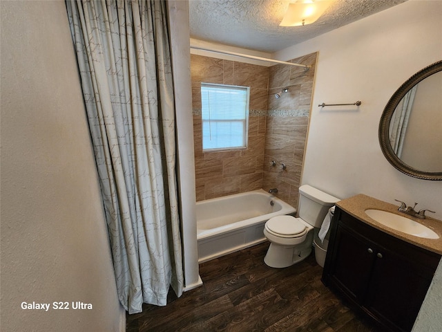 full bathroom featuring hardwood / wood-style flooring, vanity, toilet, a textured ceiling, and shower / bath combo with shower curtain